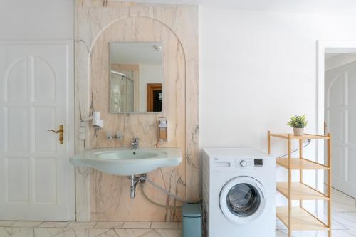 a bathroom with a sink and a washing machine at Vienna Stay Apartments Schönbrunn in Vienna