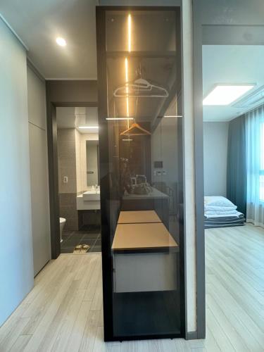 a room with a bathroom with a sink and a mirror at 더베이먼트레지던스 in Busan