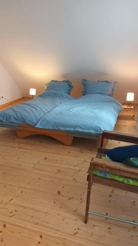 a bedroom with a bed with blue sheets and blue pillows at Ferienhaus Hoher Vogelsberg in Herbstein
