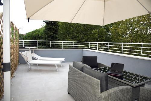 a patio with a table and chairs and an umbrella at The Three Diamonds - B&B CESENATICO in Cesenatico
