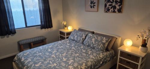 a bedroom with a bed and two tables with lamps at Warren Retreat - cozy and tranquil 2 brm home in Nannup