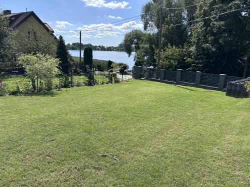 a yard with a fence and a field of grass at Pokoje Gościnne Nad Jeziorem in Rajgród