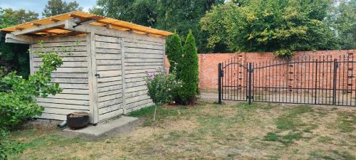 a wooden shed with a gate next to a fence at Za hrází Poděbrady in Poděbrady