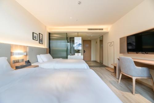 Postel nebo postele na pokoji v ubytování Suzhou Liuxiang Hotel
