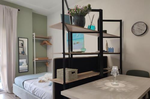 a room with a bed and a shelf with a table at Magic Home in Ceriale