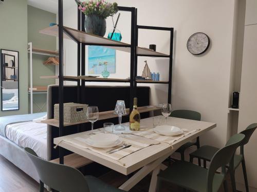 ein Esstisch mit Tellern und Weingläsern in der Unterkunft Magic Home in Ceriale