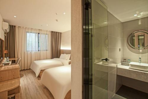 Postel nebo postele na pokoji v ubytování Suzhou Liuxiang Hotel