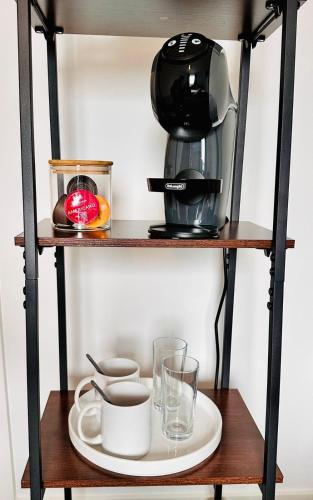 a coffee maker on a shelf with a plate and glasses at City Escape in Edinburgh