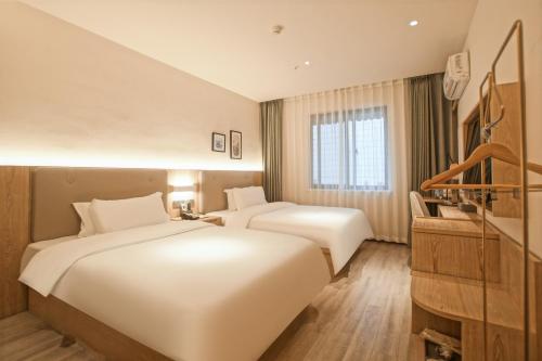 Postel nebo postele na pokoji v ubytování Suzhou Liuxiang Hotel
