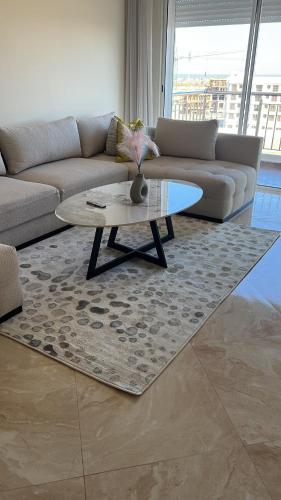 a living room with a couch and a coffee table at Luxe appartement in Bouznika
