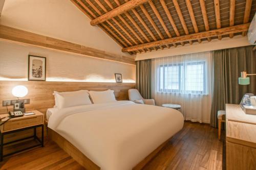 Postel nebo postele na pokoji v ubytování Suzhou Liuxiang Hotel