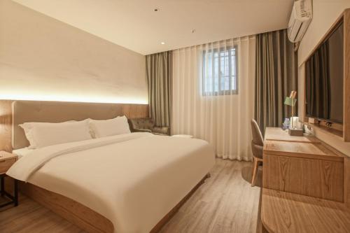 Postel nebo postele na pokoji v ubytování Suzhou Liuxiang Hotel