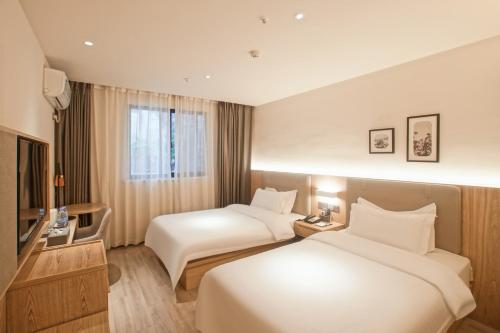 Postel nebo postele na pokoji v ubytování Suzhou Liuxiang Hotel