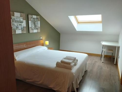 a bedroom with a bed with two towels on it at Ático Vista Alegre in Lerma
