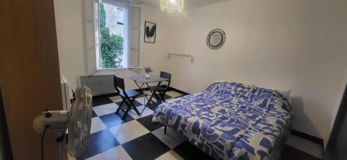 a bedroom with a bed and a table and a window at Chambre 2 - avec grande terrasse in Port-la-Nouvelle