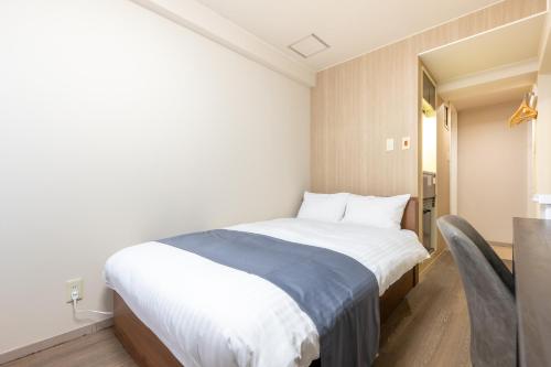 a bedroom with a bed and a table and chairs at Sleep Inn Gotanda in Tokyo