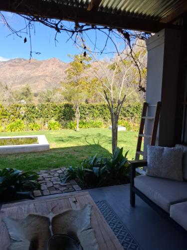a living room with a couch and a view of a yard at The Vineyard Country House in Montagu