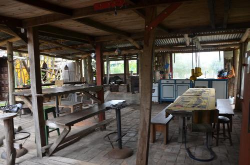 a kitchen with wooden tables and benches in a building at La Brújula Hostel in La Paloma