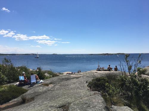 a group of people sitting on a rock near the water at Guesthouse near the sea in Västra Frölunda