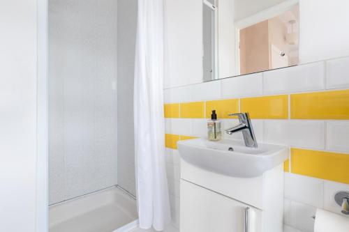 a white bathroom with a sink and a shower at Rwts Rooms & Resto in Broad Haven