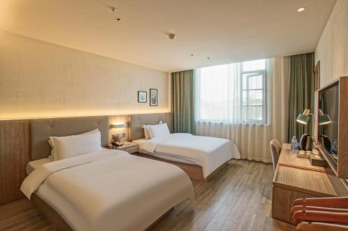Postel nebo postele na pokoji v ubytování Suzhou Liuxiang Hotel