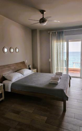 a bedroom with a large bed with a view of the ocean at Dip in the blue - 2 in Agios Georgios