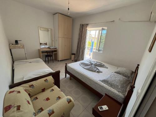 a bedroom with two beds and a desk in it at Dina House in Himare
