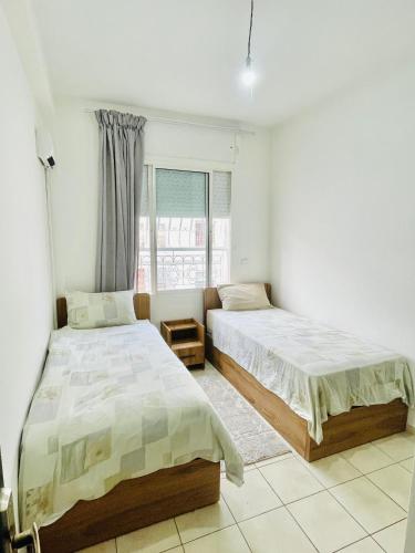 une chambre avec deux lits et une fenêtre dans l'établissement Cozy apartment, in secure residence, à Agadir