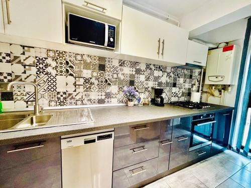 ヤシにあるOlive Apartament 3のシンクと電子レンジ付きのキッチン