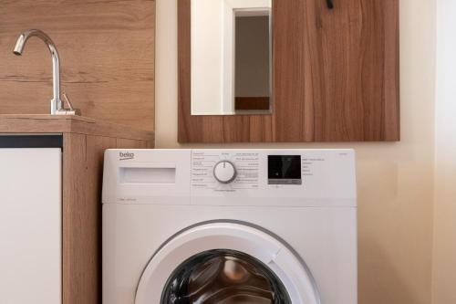 a washing machine in a kitchen next to a sink at Vienna Stay Apartments Schönbrunn in Vienna