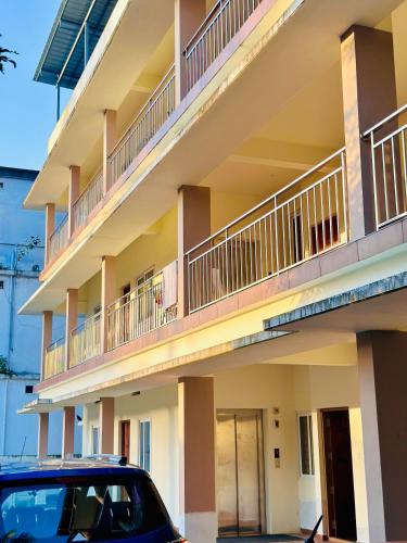 a car parked in front of a building with balconies at Hotel Haya in Ernakulam