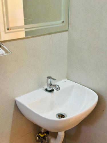 a white sink in a bathroom with a mirror at Hotel Haya in Ernakulam