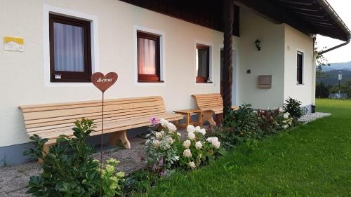 a house with a bench with a heart painted on it at Ferienhaus Am Riedl in Siegsdorf