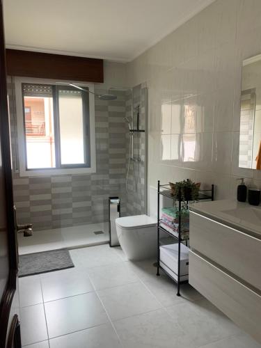 a bathroom with a shower and a toilet and a sink at O eido in Aldán