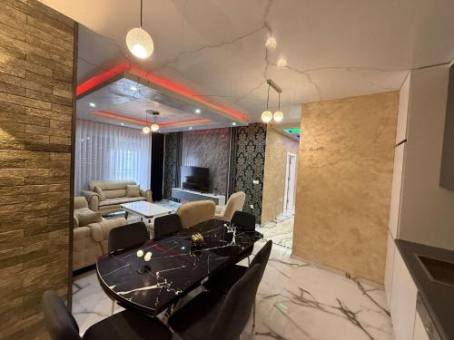 a dining room with a table and a living room at BB Apartment Prishtina in Pristina