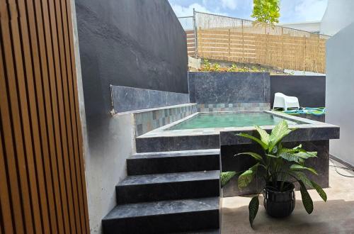 uma piscina com escadas e uma planta em vaso em Modern private home with Pool, Patio and Sundeck em San Juan