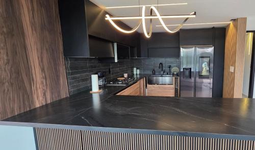 uma cozinha com uma grande bancada preta em Modern private home with Pool, Patio and Sundeck em San Juan