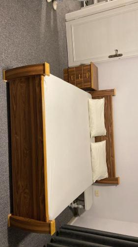 a staircase with a white and wooden bed with pillows at aljumirah furnished appartments الجميرا للشقق المفروشة in Az Zarqa