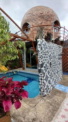 a house with a swimming pool next to a building at El Domo Macanal in Macanal