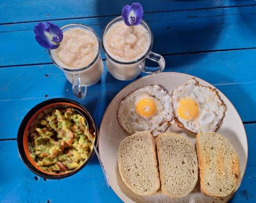 a table with eggs and a plate of food and drinks at daTerra Baucau agroecological farm stay in Deli