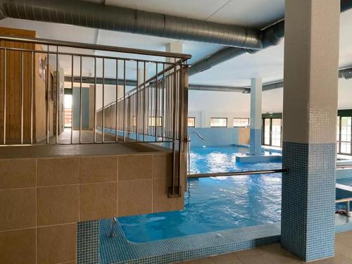 a swimming pool with a staircase in a building at Costa SPA Superior de lujo - Playa de las Catedrales in San Miguel de Reinante