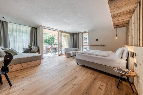 a bedroom with two beds and a large window at Monroc Hotel in Commezzadura
