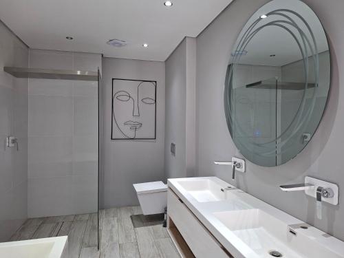 a bathroom with two sinks and a mirror at CView Suites & Apartments in Pretoria