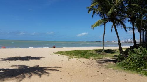 a sandy beach with palm trees and the ocean at Pousada Jasmine in João Pessoa