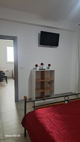 ママイア・ノルドにあるApartament zona Manara beachのベッドルーム1室(壁にテレビ付)、ベッド1台が備わります。