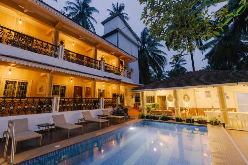 a hotel with a swimming pool in front of a building at Pvt Pool - Villa Azura Escape - Casa Marialina 8 BR in Saligao