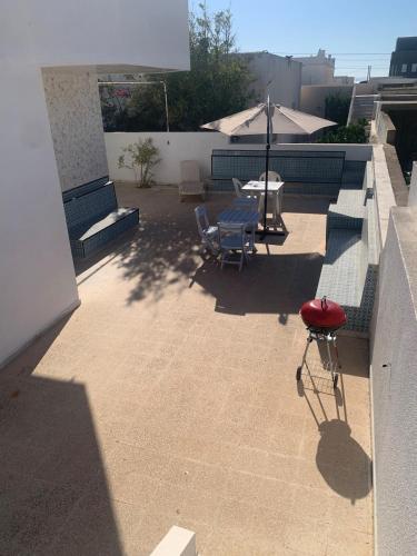 a patio with a table and an umbrella on a building at Villa Soliman Plage in Soliman