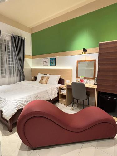a bedroom with a bed and a desk with a chair at Summer Hotel in Dĩ An
