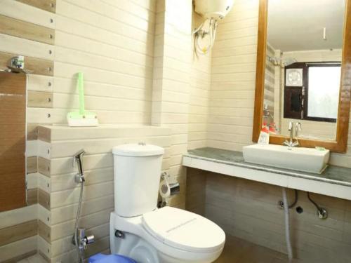 a bathroom with a white toilet and a sink at Eiyuu Hotels - Wildlife & Nature Vista in Jhirna