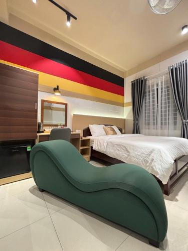 a bedroom with two beds and a green couch at Summer Hotel in Dĩ An
